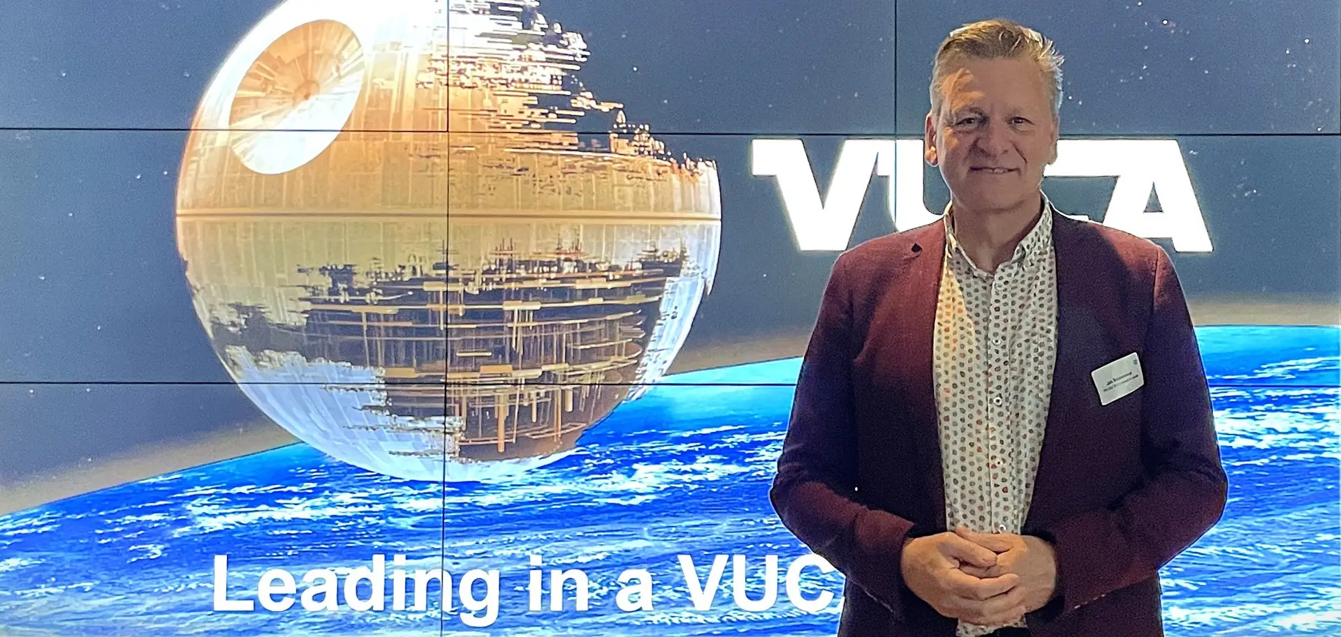 Man in front of VUCA screen presenting opening slide of VUCA@Work web-event